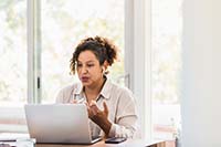 Photo of a clinician working with a client through a teleconference call 